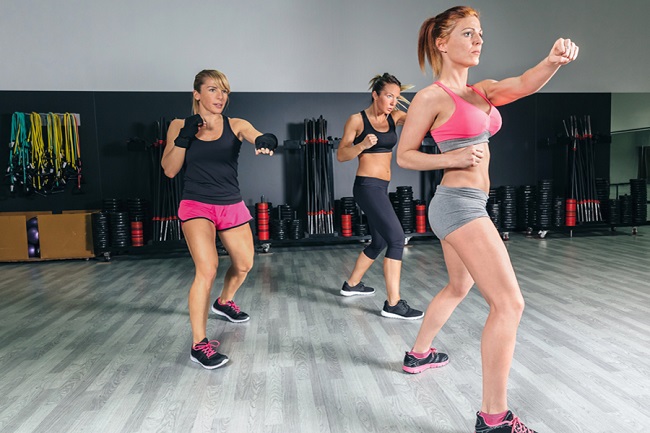 Group of beautiful women in a hard boxing class on gym training punch